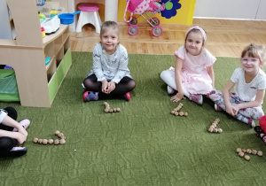 Dzieci układają cyfrę 1 z orzechów włoskich